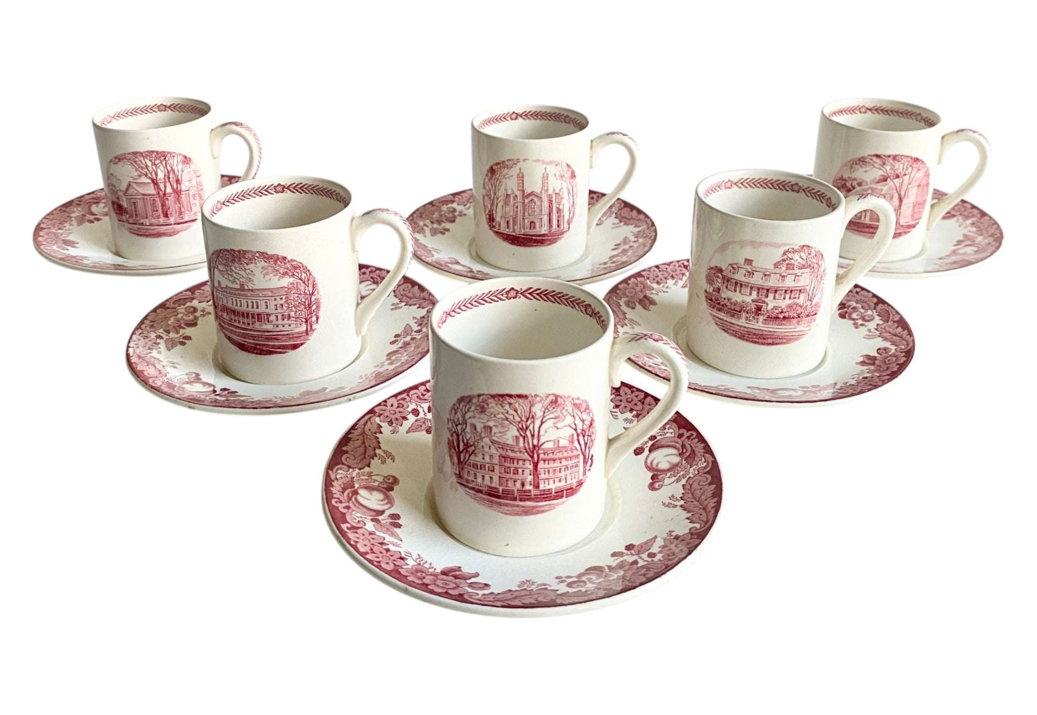 Set of six white cups and saucers with red floral patterns on a white background