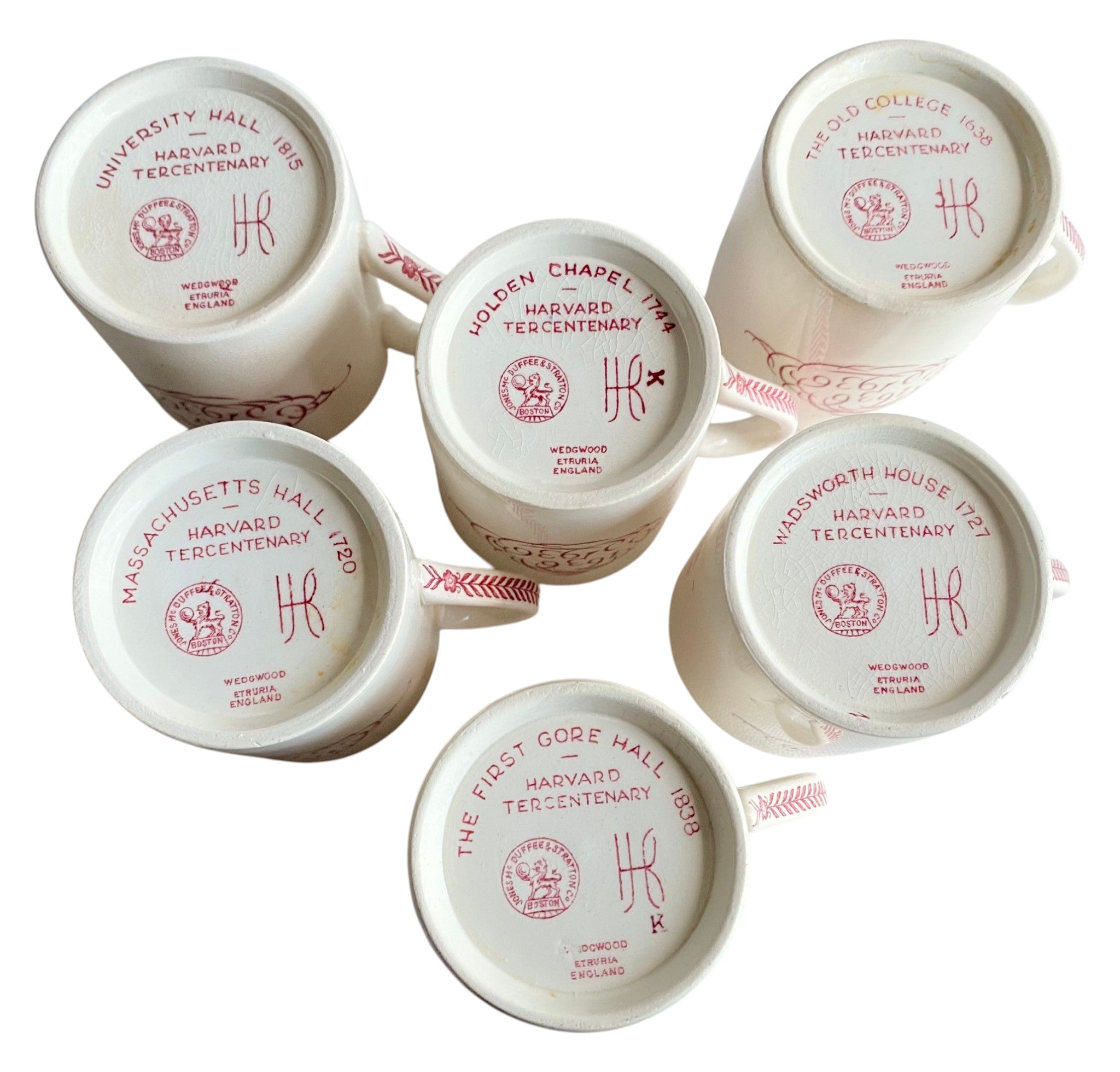 Set of white mugs with red Harvard Tercentenary branding on a white background
