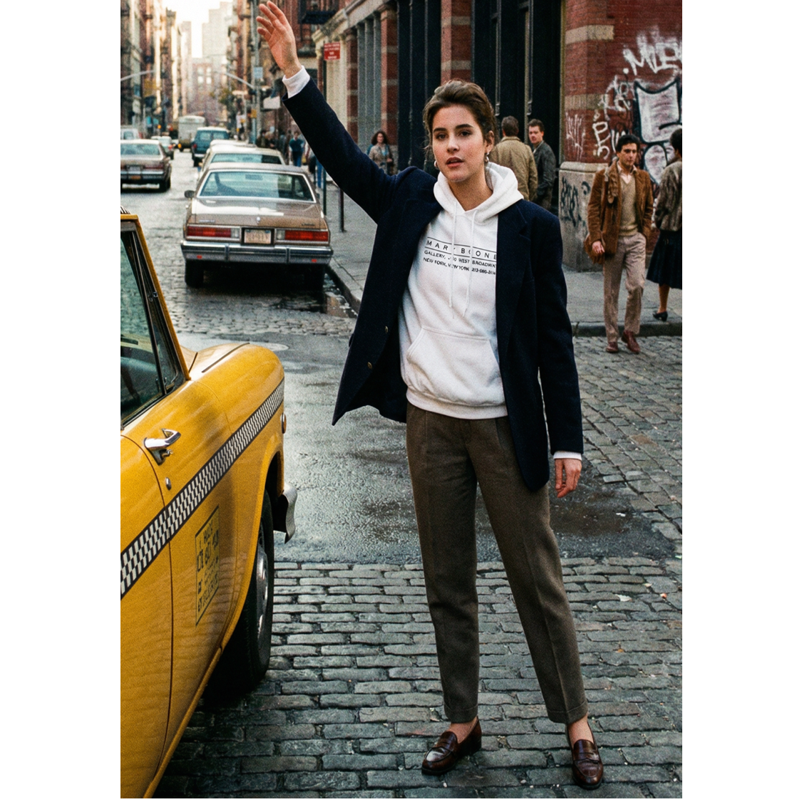 Person standing on a city street with a yellow taxi in the background